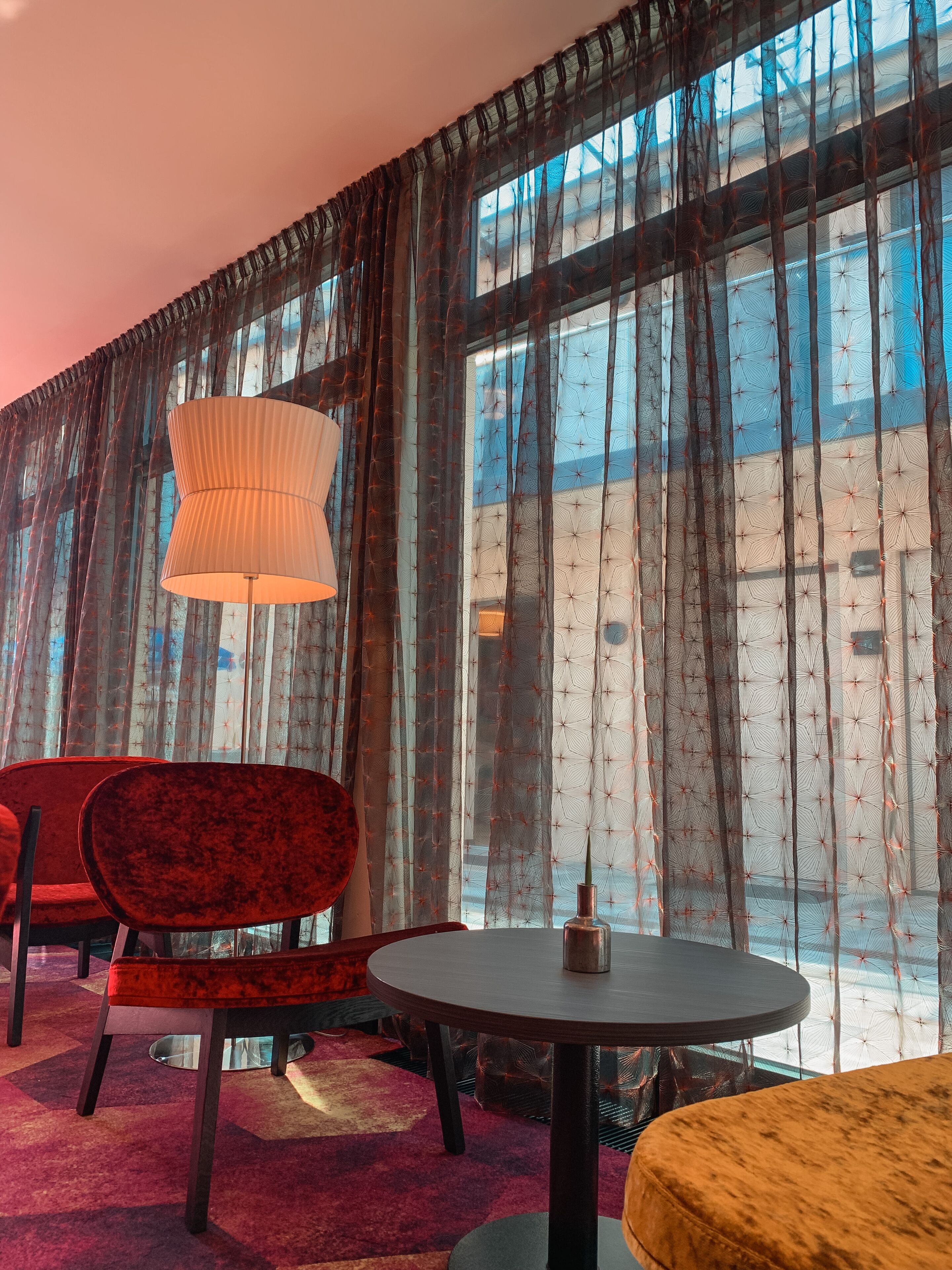 Ein Zimmer mit einem großen Fenster, einem runden Tisch und zwei Stühlen.