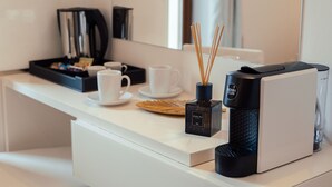 A modern kitchen with a coffee machine, a bottle of Culti, and a set of white cups on a white countertop. - Torre A Mare Porto Venere (Portovenere)