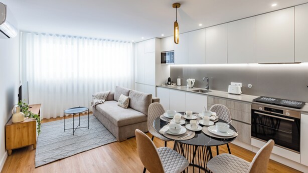 Una cocina moderna con comedor, un sofá y una pequeña mesita auxiliar.