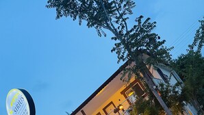 A hotel with a signboard, multiple balconies, and outdoor seating areas. - Sirius Otel Pamukkale (Denizli)