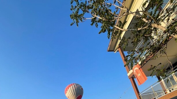 A swimming pool with a hot air balloon in the background. - Sirius Otel Pamukkale (Denizli)