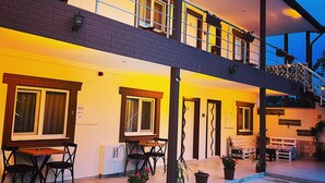 A two-story building with a balcony, outdoor seating area, and potted plants. - Sirius Otel Pamukkale (Denizli)