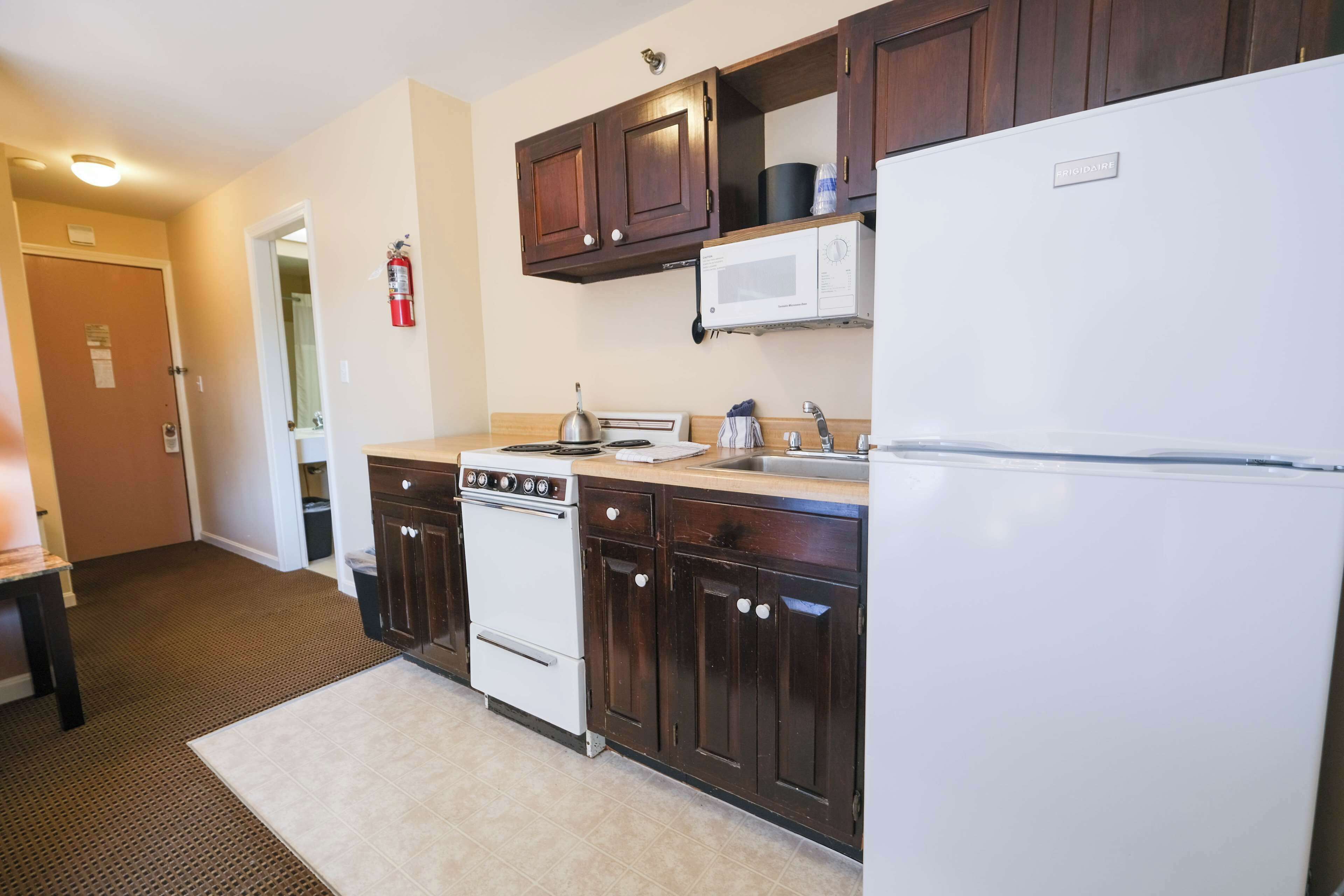 Cocina compacta con estufa, microondas y refrigerador.