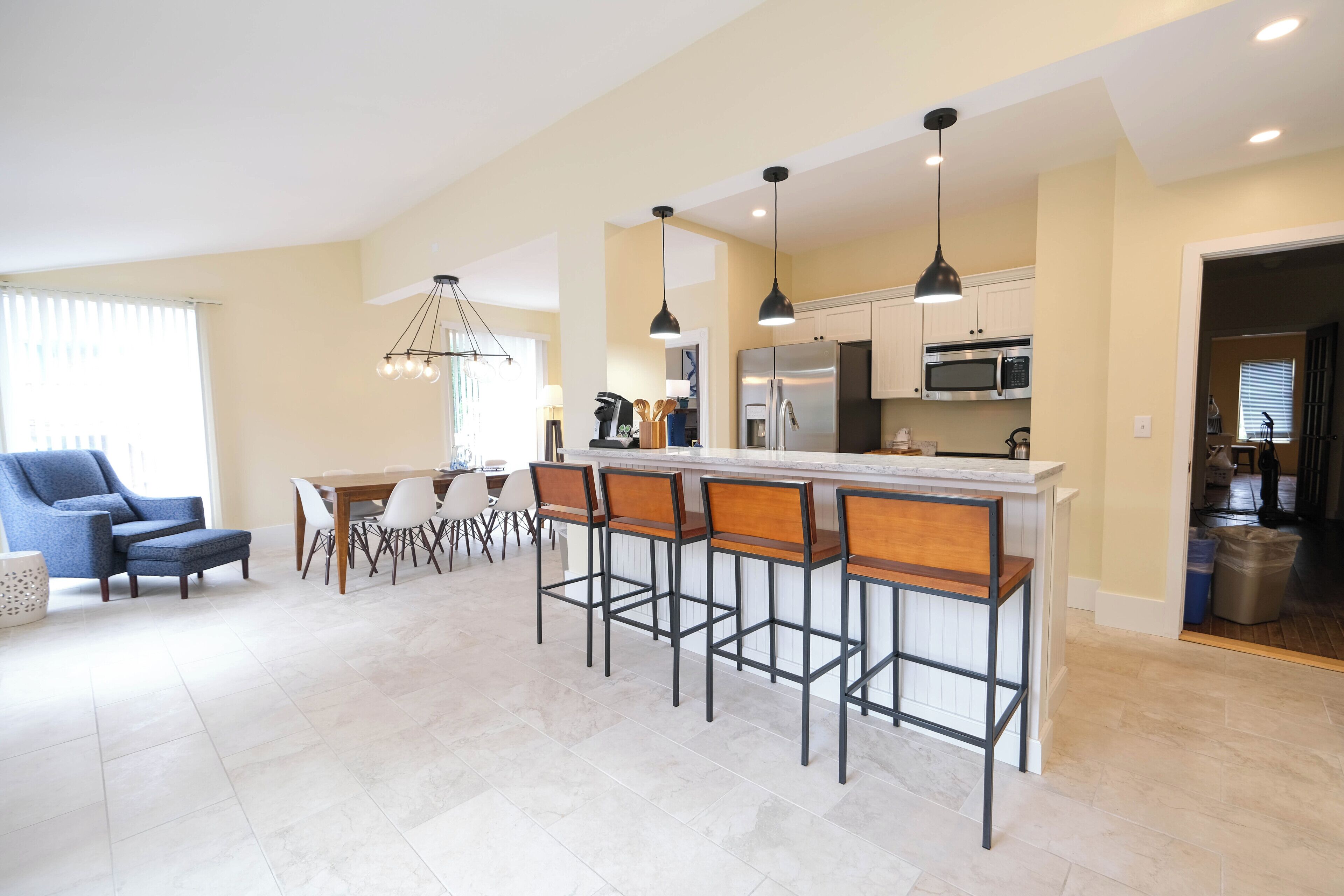A modern kitchen with a central island, bar stools, and contemporary appliances.