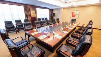 A conference room with a long table, multiple chairs, and a chandelier.