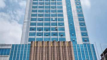 A tall building with a modern design, featuring a series of windows and a prominent entrance area.