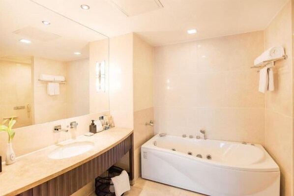 A modern bathroom with a large mirror, a sink, a bathtub, and a towel rack. - Shenlong New World Hotel (Leiyang)