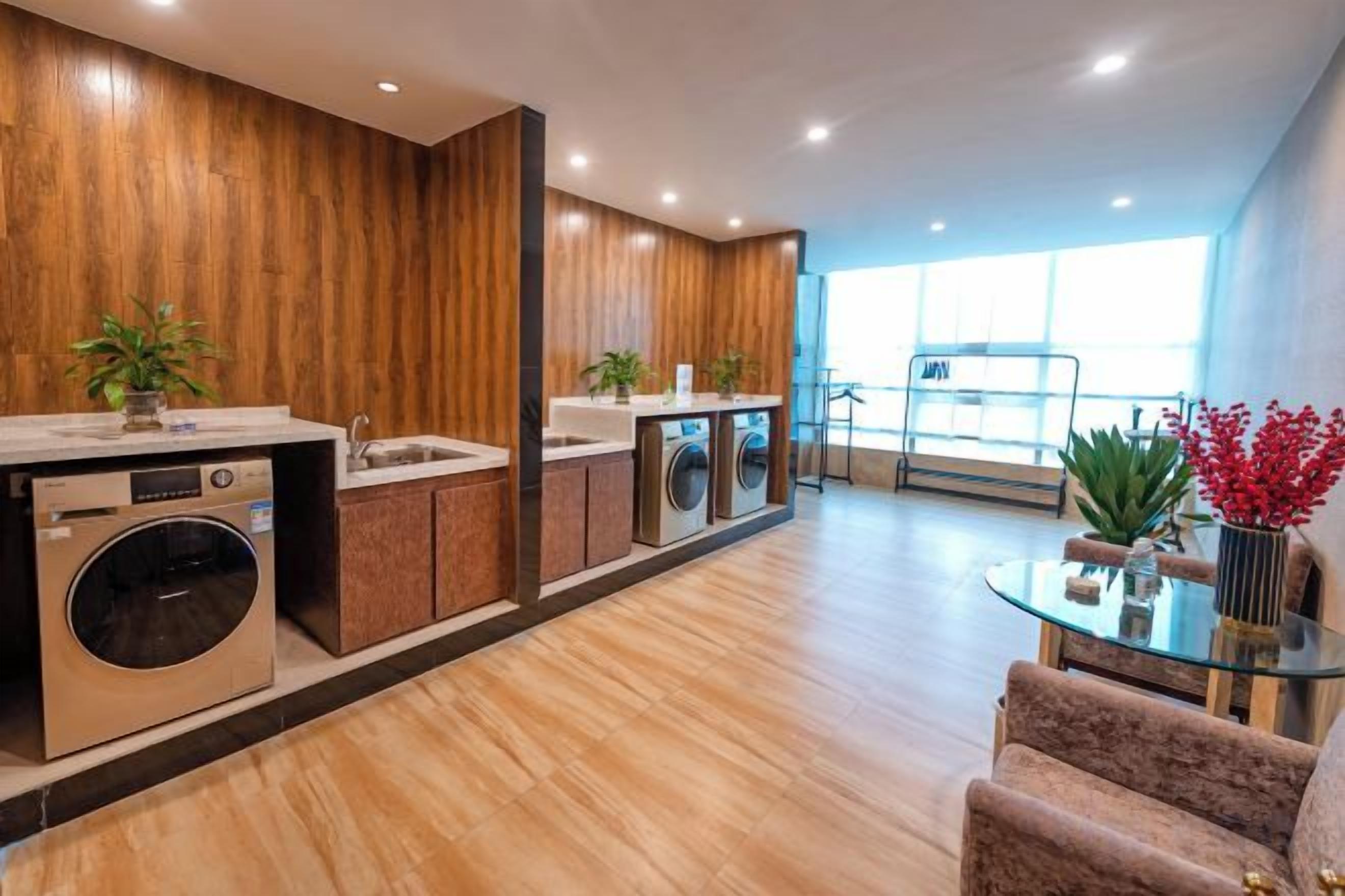 Una cocina moderna con electrodomésticos integrados, un comedor con mesa de vidrio y vistas al exterior.