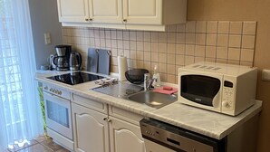 A kitchen with white cabinets, a microwave, a dishwasher, and a stove.