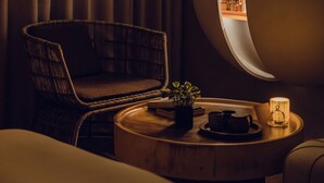 A cozy room with a round table, a wicker chair, a potted plant, and a lit lamp. - Vivir Jiaoxi Hotel (Jiaoxi)