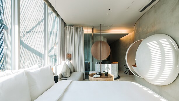 A modern hotel room with a large bed, a round wooden table, and a large mirror. - Vivir Jiaoxi Hotel (Jiaoxi)