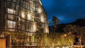 A modern building with a unique angular design, featuring multiple levels and large windows. - Vivir Jiaoxi Hotel (Jiaoxi)