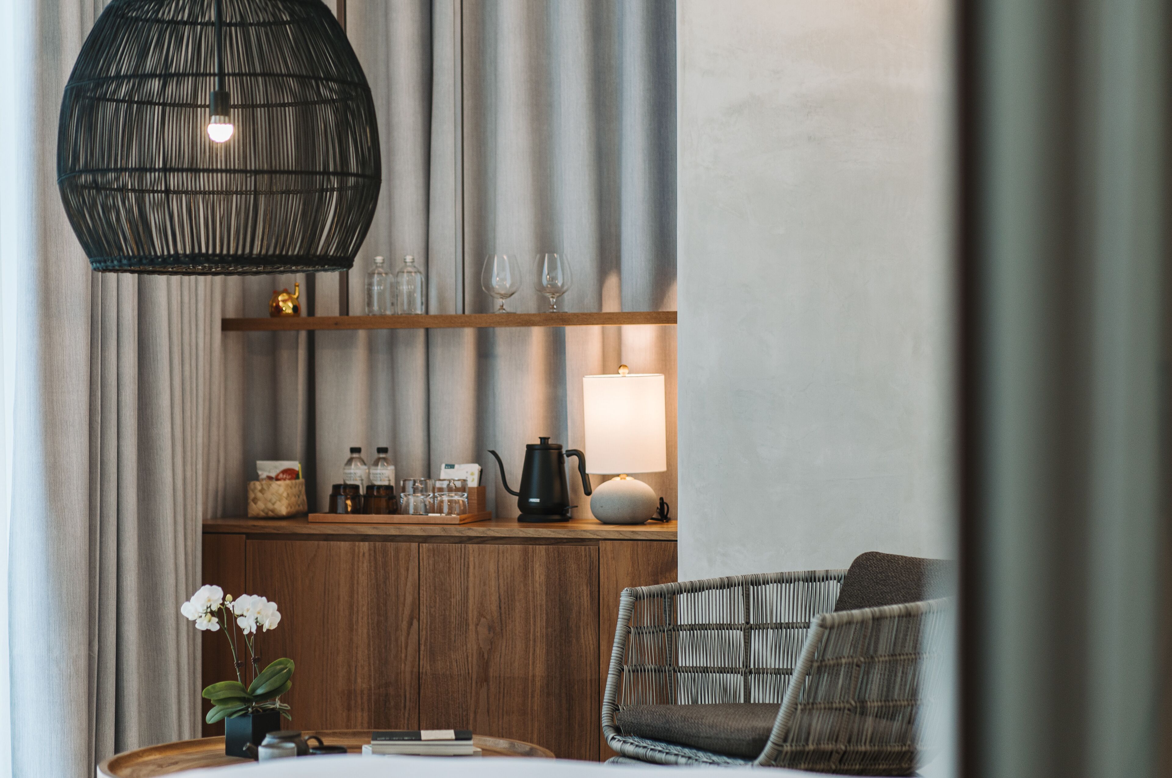 A cozy room with a wooden counter, a hanging light fixture, and a comfortable chair.
