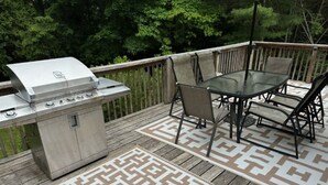 An outdoor deck with a grill, a table, and chairs. - Great Home in South County, Close to Narraganstt and Newport &.08 miles from URI (South Kingstown)