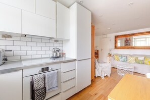 A modern kitchen with white cabinetry, a kettle, and a toaster. - Peaceful Hidden Gem, Heart of South East London (London)