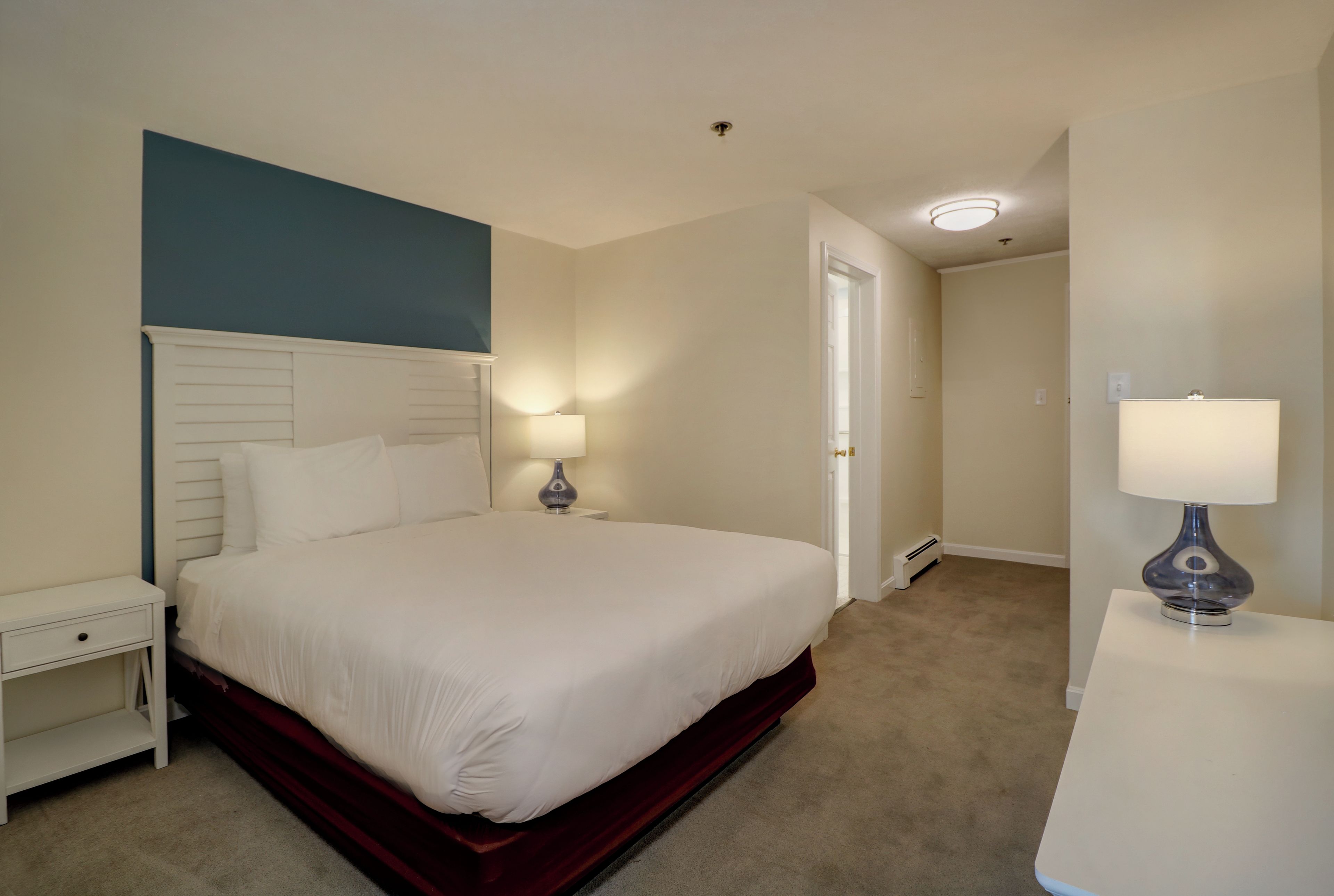 Un dormitorio con cama, mesita de noche y lámpara de noche.
