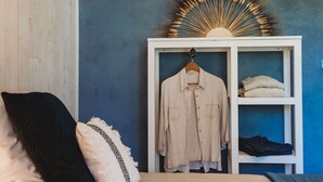 Une chambre à coucher avec un lit, une armoire blanche et un motif décoratif en forme de soleil sur le mur.