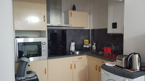 Cocina compacta con microondas, tostadora y lavadora.