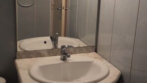 Un baño con lavamanos, espejo y retrete.