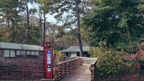 A wooden bridge leading to a building with a sign indicating directions to Nags Head and Nags Head Preserve. - Hale Aloha: An Aloha-Inspired Escape in the OBX (Kill Devil Hills)