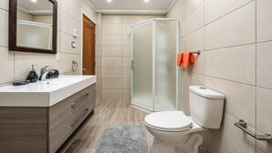 A modern bathroom with a white sink, wooden vanity, a glass shower enclosure, and a toilet. - Spacious 3 beds Loft with Parking($14/day) (Montréal)