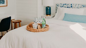 A hotel room with a bed, a ceiling fan, a bedside table with a lamp, and a wall-mounted picture. - NEW boutique, luxury rental in Downtown Petoskey! Dogs welcome! (Petoskey)