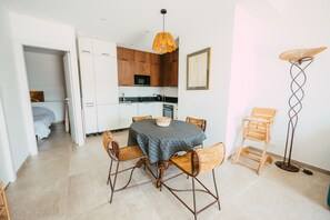 Cozy living space with a dining table, kitchenette, and modern lighting.
