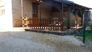 A rustic building with a wooden porch and a gravel driveway. - country house (Frayssinet-le-Gélat)
