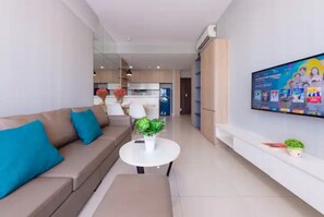 Ein modernes Wohnzimmer mit einer Couch, einem Couchtisch und einem flachbildfernseher an der Wand.