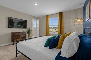 Cozy retreat with a large bed, dresser, and flat-screen TV.
