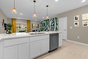 Enjoy cooking in this well-equipped kitchen with a central island, stainless steel dishwasher, and ample counter space.