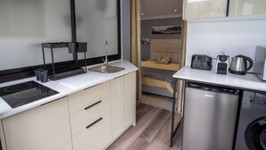 A compact kitchen with a built-in dishwasher, a small sink, and a toaster. - Camps Bay Echo Garden Apartment (Cape Town)