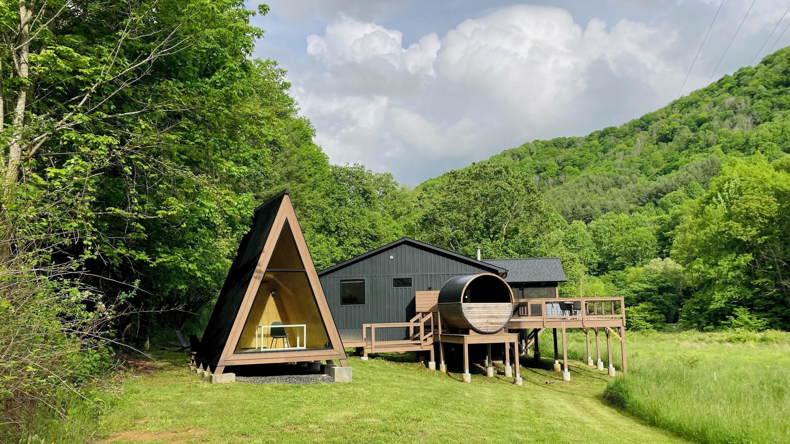 View of home, barrel sauna, A-frame, deck w/hot tub, shower, screened porch