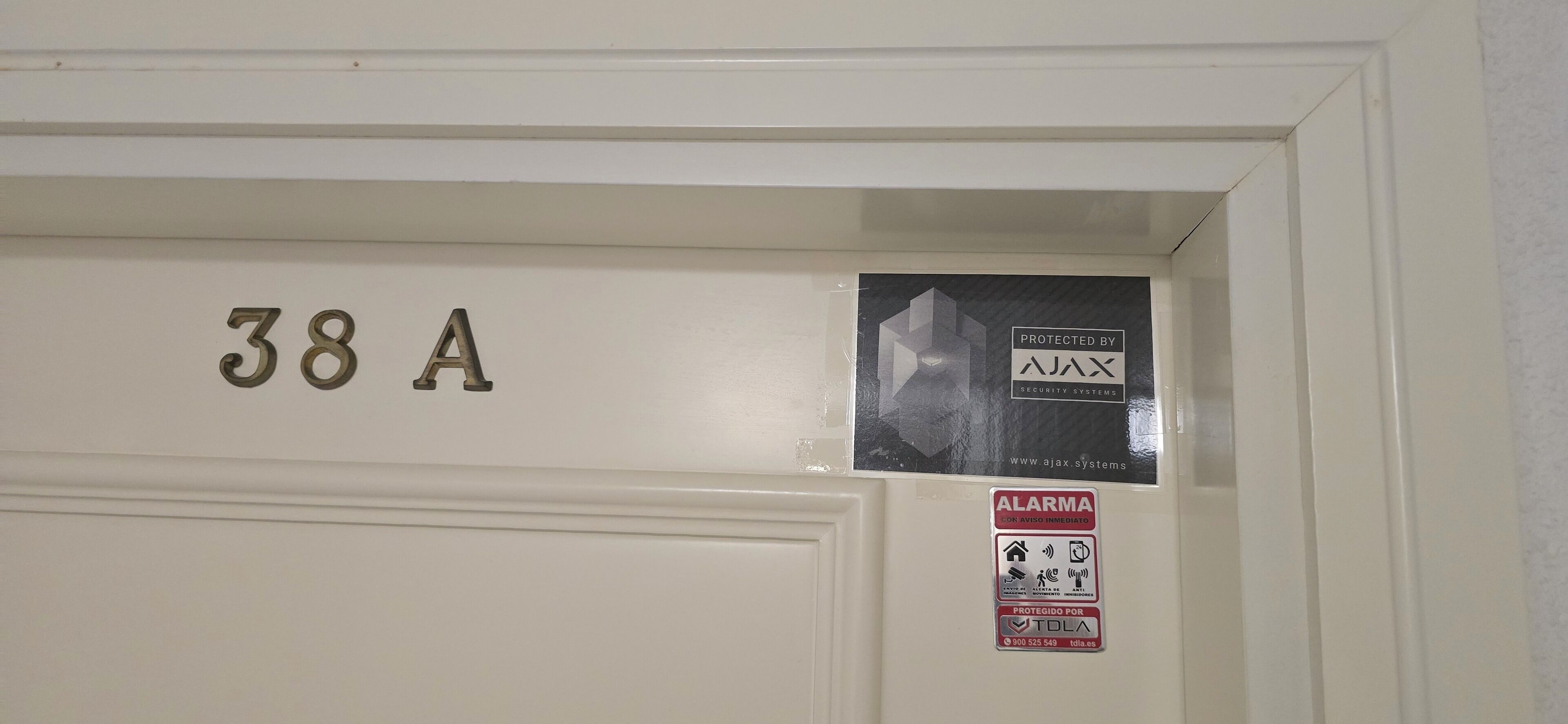 A door with the number "38A" and a security system sign.