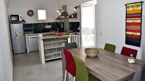 A compact kitchen with a dining area, a microwave, a stove, and a sink. - Chez Angelina Positano (Positano)