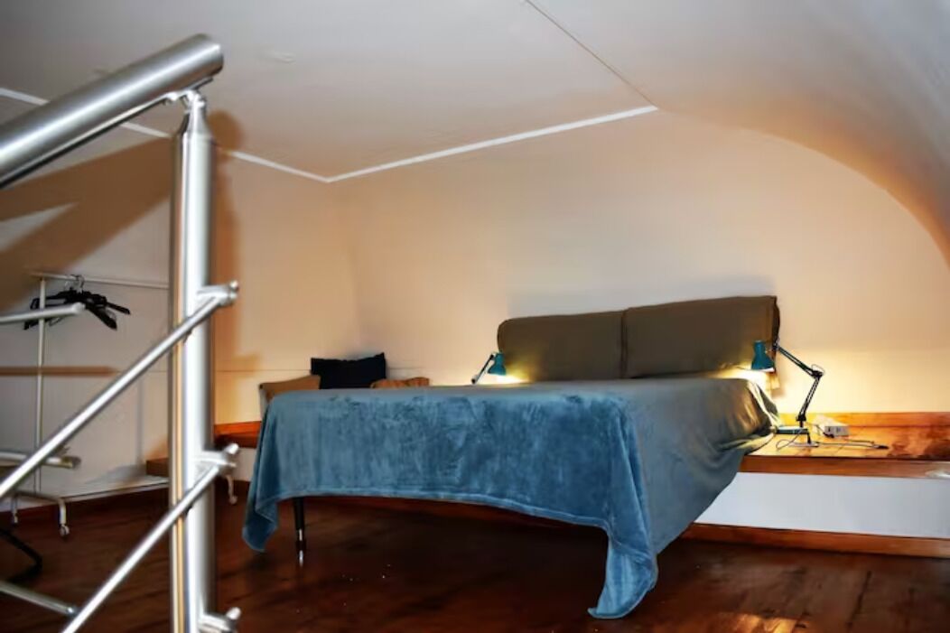 A bedroom with a bed, a desk, and a chair.