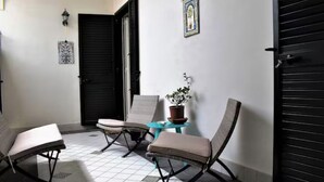 A tiled patio area with two lounge chairs and a small table with a potted plant. - Chez Angelina Positano (Positano)