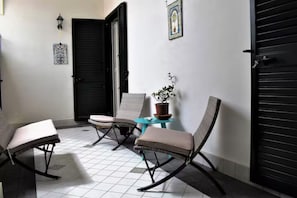 Relax in this serene outdoor space with a round table and comfortable seating for three.