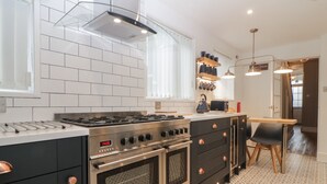 Cocina moderna con estufa integrada, horno y un reloj digital que marca las 14:26.