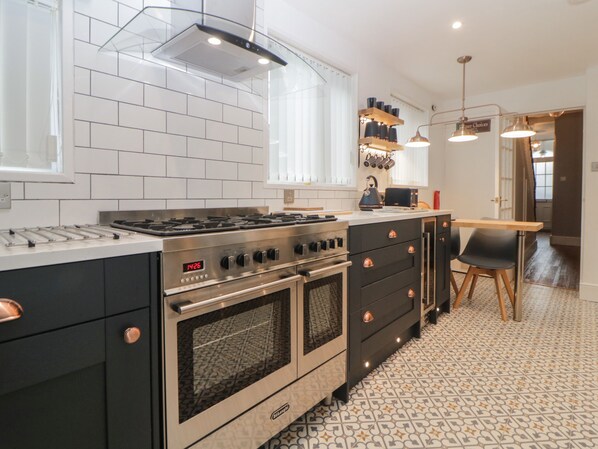 A modern kitchen with a built-in stove, oven, and a digital clock displaying 14:26. - Cornerside (Sidmouth)
