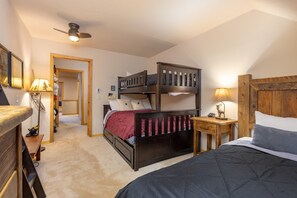 A bedroom with a bunk bed, a desk with a lamp, and a ceiling fan. - Sunny and Spacious Condo/Pool and Hot Tub Access (Keystone)