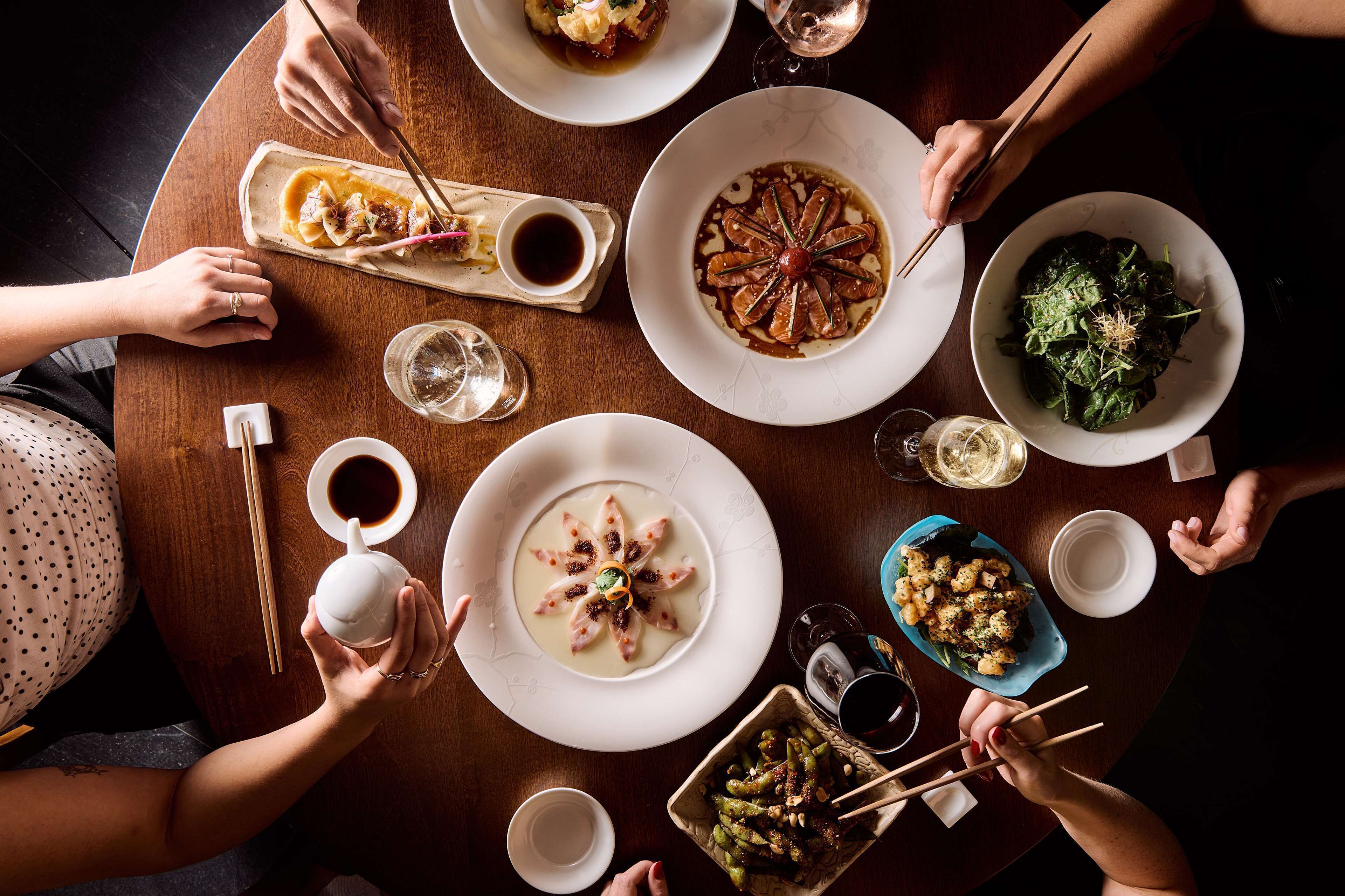 A round dining table with various dishes and drinks.