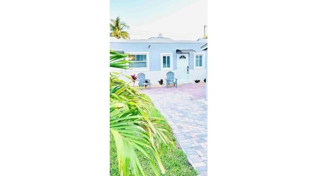 A building with a paved entrance and a small patio area with two chairs. - Sunny and cozy place (Delray Beach)