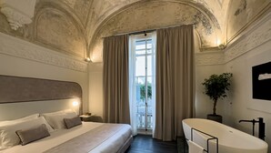 Un dormitorio con una cama grande, un baño moderno y vistas al exterior.