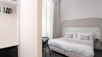 Ein modernes Schlafzimmer mit einem großen Bett, einem Nachttisch und einem Sessel.