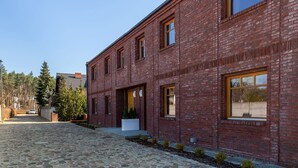 Un edificio de ladrillo rojo con grandes ventanales y una entrada empaveda de piedra.