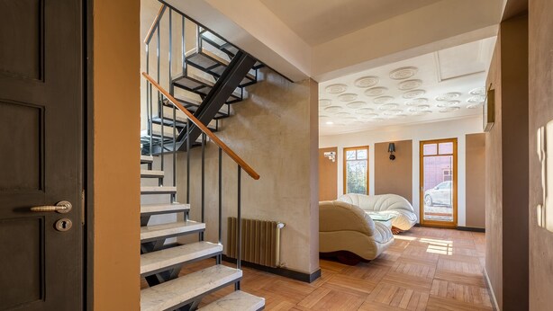Un interior moderno con una escalera, una cama y un radiador.