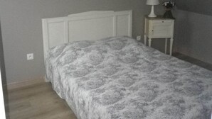 Ein Schlafzimmer mit einem Bett, einem Nachttisch und einem Wandbild.