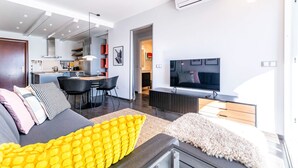 A modern living room with a sofa, TV, and dining area. - Apartment in the Heart of Fuengirola (Fuengirola)