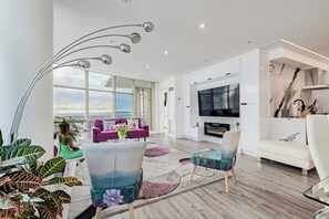 Relax in a spacious living room with a large flat-screen TV, comfortable seating area, and a fireplace.
